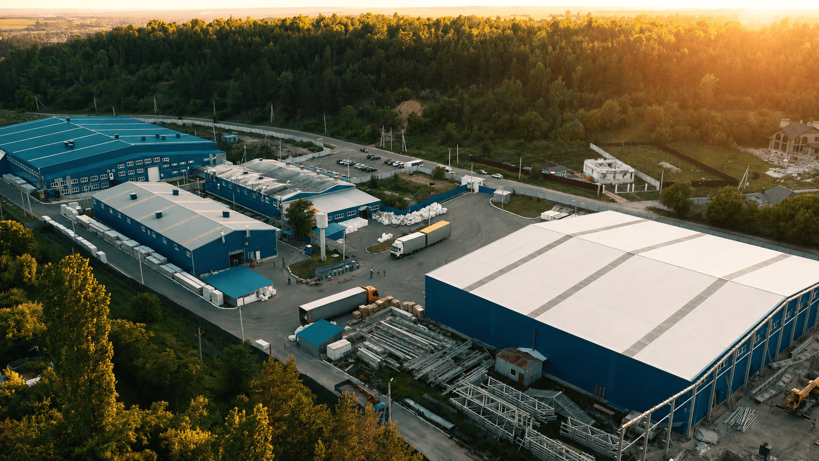 An aerial view of an industrial warehouse and logistics park at dusk